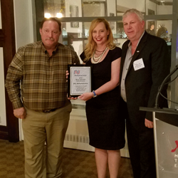 Jane Clark of NationaLease presenting an award to Kevin Hoyt (left) of VEL NationaLease and Peter Cook (right) of VEL NationaLease